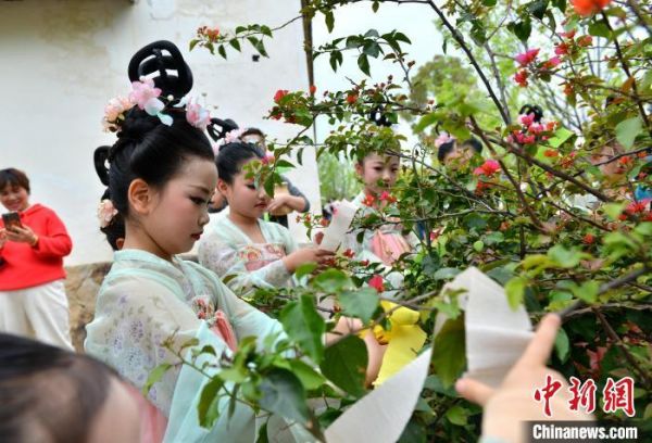 图为“赏花”仪式，小朋友手持各色彩带系向现场的各色花枝。中新网记者吕明摄